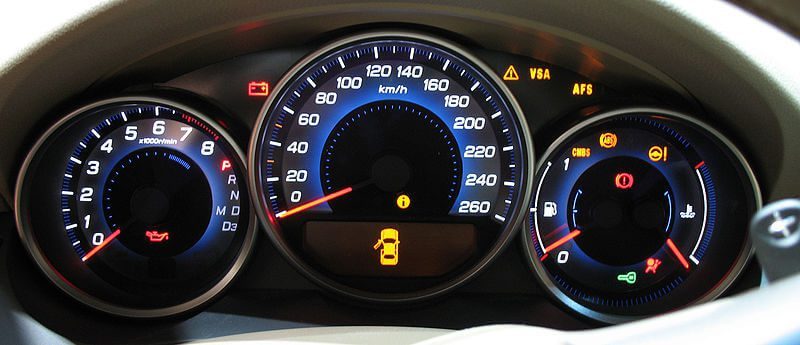 A car instrument cluster showing the speedometer, rev counter and warning lights