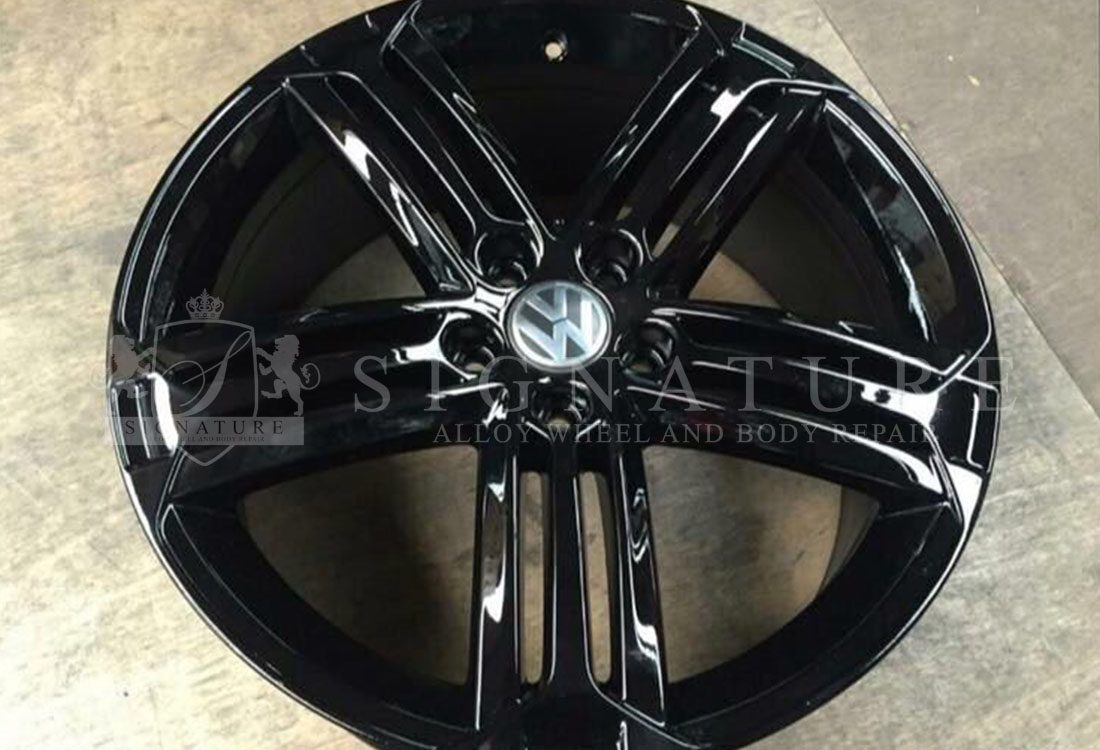 Technician refinishing a kerbed alloy wheel