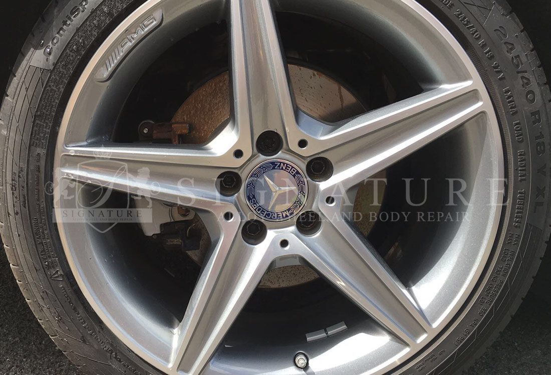 Silver Mercedes five spoke alloy wheel after a kerb scuff repair