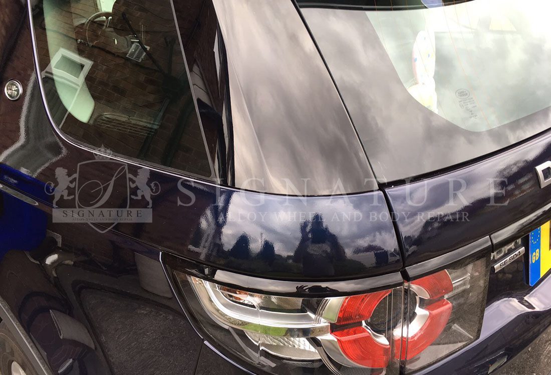 Rear quarter and light cluster of a black estate car after a body repair