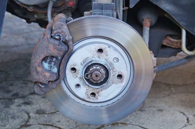 A worn brake pad resting against a car brake disc