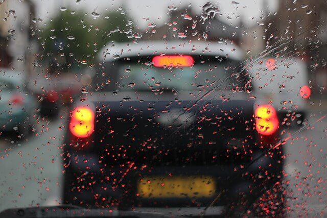 The interior of a car seen through the windscreen on a wet day with rain on the glass