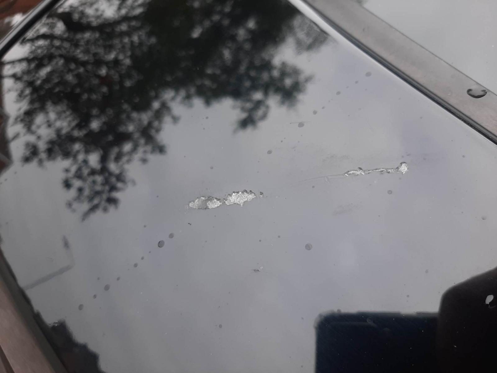 Deep scratches through the paint on a white body panel