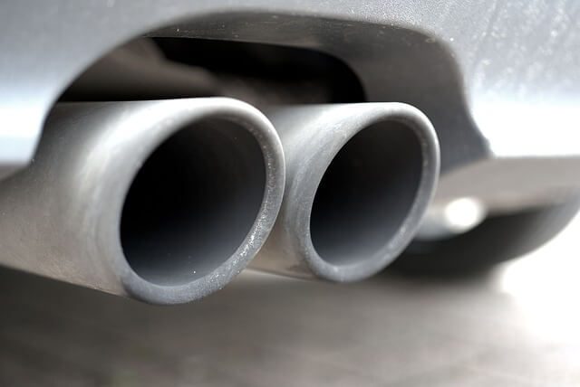 Twin chrome exhaust tailpipes at the rear of a car