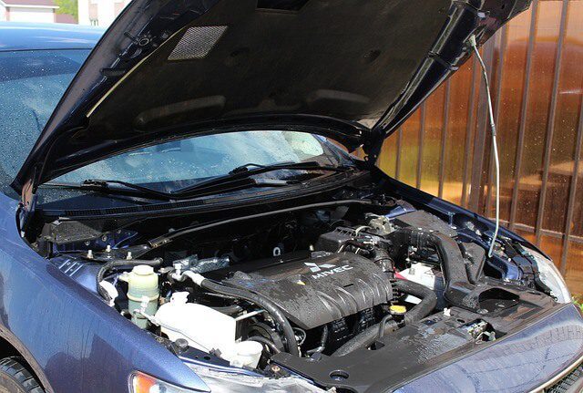 A car engine bay photographed with the bonnet raised