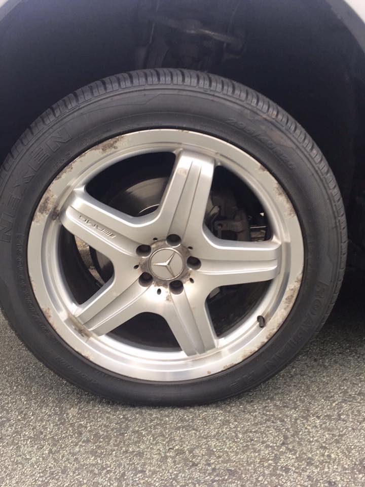 Close up of a kerbed silver alloy wheel on a Mercedes parked on a driveway