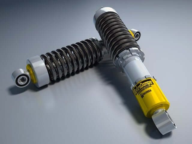 Two coilover shock absorbers with yellow bodies and coil springs