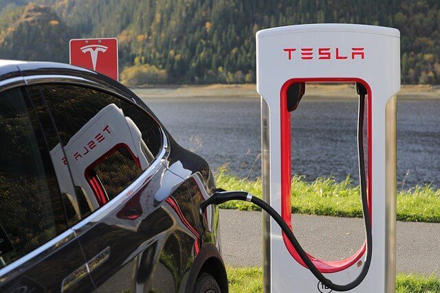 A modern electric car parked on a road with trees in the background