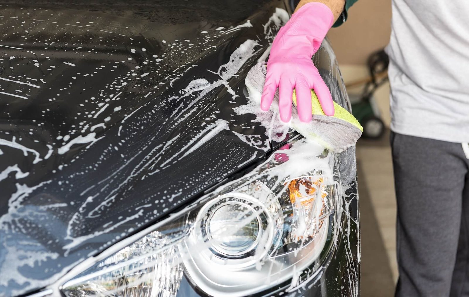 A car being washed with a soapy cloth in preparation for waxing